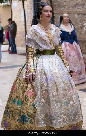 Les femmes dans les parures traditionnelles font revivre les rues de Gandia, leurs robes un kaléidoscope d’histoire et de célébration. Chaque pli raconte une histoire, le tissage Banque D'Images