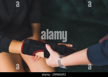 une femme aidant une autre femme à mettre une attelle sur son majeur, traitement à domicile. Photo de haute qualité Banque D'Images