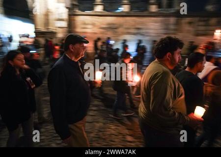 Antigua, Guatemala. 22 mars 2024. Les dévots portant des bougies, marchent le long d'un palanquin avec la cruxifixction de la statue de Jésus Christ lors d'une procession silencieuse de 3h du matin du Templo San Francisco el Grande, le 22 mars 2024 à Antigua, Guatemala. Les processions opulentes, les algèbres détaillées et les traditions séculaires attirent plus d'un million de personnes dans l'ancienne capitale. Crédit : Richard Ellis/Richard Ellis/Alamy Live News Banque D'Images