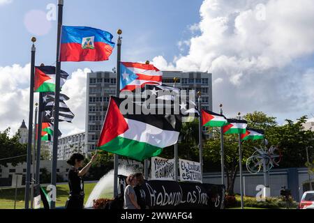 San Juan, États-Unis. 22 mars 2024. Les manifestants ont changé les drapeaux des États-Unis généralement vus sur ces mâts de drapeaux avec des drapeaux haïtiens, palestiniens et portoricains en noir et blanc lors d'une manifestation pour protester contre la visite du vice-président Kamala Harris à Porto Rico à San Juan, Porto Rico, le vendredi 22 mars 2024. (Photo de Carlos Berríos Polanco/Sipa USA) crédit : Sipa USA/Alamy Live News Banque D'Images