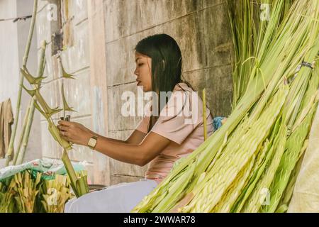 Antipolo City, Rizal, Philippines. 23 mars 2024. Les gens préparent des branches de palmier à côté de la rue en commémoration du dimanche des Rameaux à Antipolo City, Philippines, le 23 mars 2024. Les frondes de palmier ont été historiquement liées à la victoire et au triomphe dans de nombreuses cultures. Les fidèles catholiques symbolisent le dimanche des Rameaux comme le début de la semaine Sainte. (Crédit image : © Ryan Eduard Benaid/ZUMA Press Wire) USAGE ÉDITORIAL SEULEMENT! Non destiné à UN USAGE commercial ! Banque D'Images