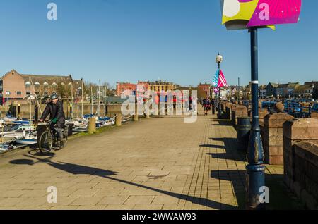 Bangor, County Down, Irlande du Nord 20 mars 2024 - les gens marchent et font du vélo le long de la promenade près de la marina de Bangor Co. Bas Banque D'Images