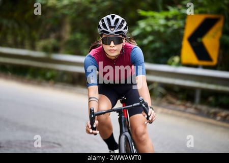 jeune femme asiatique cycliste femme chevauchant le vélo à l'extérieur sur la route rurale Banque D'Images