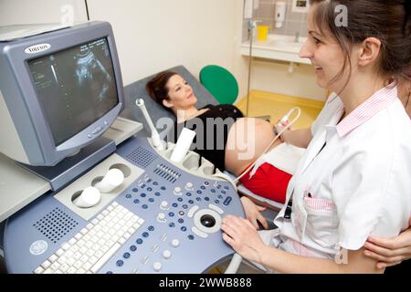 Hôpital. Maternité. étudiante sage-femme de 4e année réalisant une échographie prénatale sous la supervision d'une sage-femme. 24 semaines, 6 mois femme enceinte. Banque D'Images