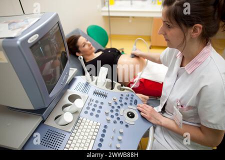 Hôpital. Maternité. étudiante sage-femme de 4e année réalisant une échographie prénatale sous la supervision d'une sage-femme. 24 semaines, 6 mois femme enceinte. Banque D'Images