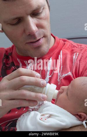 Père donnant le biberon à son enfant à la maternité. Banque D'Images