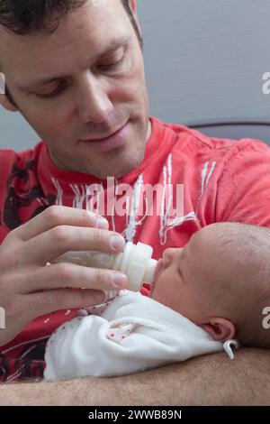 Père donnant le biberon à son enfant à la maternité. Banque D'Images