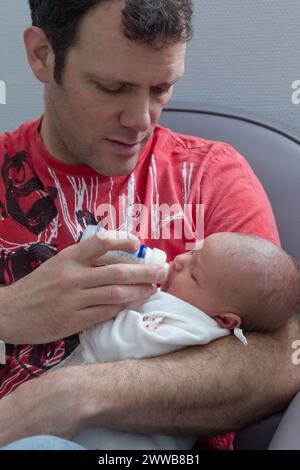Père donnant le biberon à son enfant à la maternité. Banque D'Images