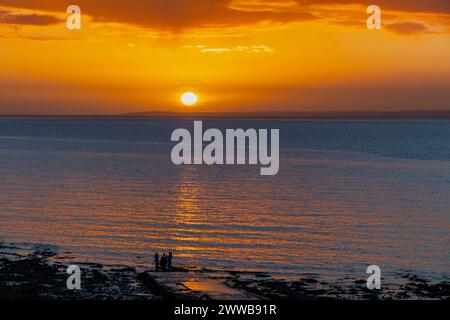 Le soleil sur le point de se coucher sur la côte galloise Banque D'Images