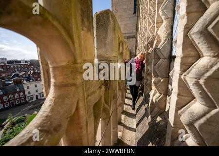 Le personnel et les bénévoles de la cathédrale de Gloucester effectuent les derniers contrôles et les préparatifs en hauteur sur un rebord de la tour de la cathédrale, où elle sera ouverte au public pour la saison 2024 des visites guidées. Date de la photo : vendredi 22 mars 2024. Banque D'Images