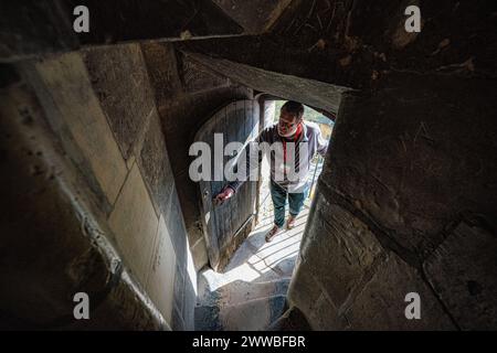 Le personnel et les bénévoles de la cathédrale de Gloucester effectuent les vérifications finales et les préparatifs à l’intérieur d’un escalier médiéval, en hauteur dans la tour de la cathédrale, où il sera ouvert au public pour la saison 2024 de visites guidées. Date de la photo : vendredi 22 mars 2024. Banque D'Images