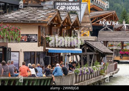 Foule de gens dans un café en plein air avec de la musique live donnant sur la rivière Arve à l'happy hour en été, Chamonix, haute Savoie, France Banque D'Images