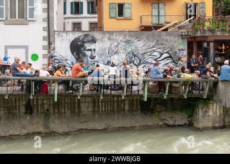 Foule de gens dans un café en plein air avec de la musique live donnant sur la rivière Arve à l'happy hour en été, Chamonix, haute Savoie, France Banque D'Images