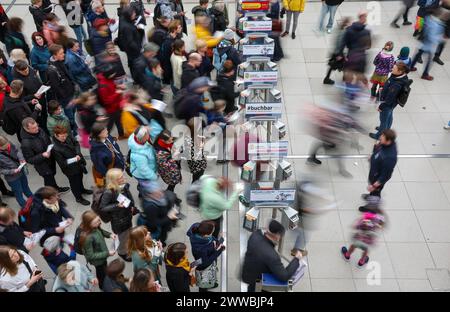 Leipzig, Allemagne. 23 mars 2024. De nombreux visiteurs passent par les tourniquets de la Foire du livre de Leipzig. Plus de 2000 exposants de 40 pays présentent leurs nouveaux produits à la réunion de printemps de l'industrie du livre. Crédit : Jan Woitas/dpa/Alamy Live News Banque D'Images