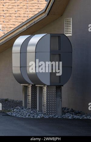 deux grandes pompes à chaleur devant un mur de maison gris Banque D'Images