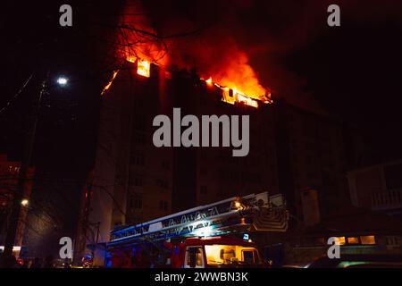 Le camion de pompiers et la maison en feu sont engloutis dans les flammes. Banque D'Images