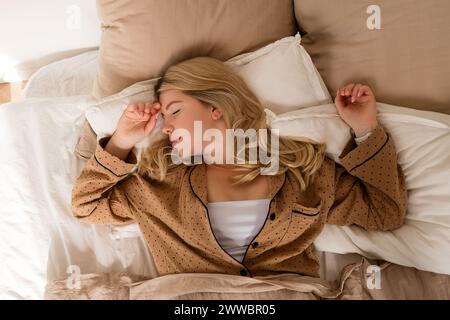 Femme s'étirant dans le lit après le réveil. Sommeil sain complet Banque D'Images
