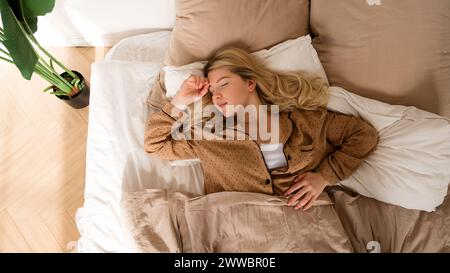 Femme s'étirant dans le lit après le réveil. Sommeil sain complet Banque D'Images