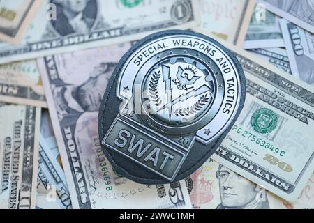 KIEV, UKRAINE - 9 MARS 2024 badge SWAT américain sur de nombreux billets en dollars américains Fermer Banque D'Images