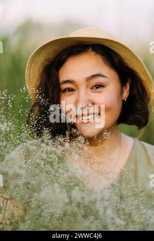 Femme mature souriante avec des fleurs de gypsophila Banque D'Images