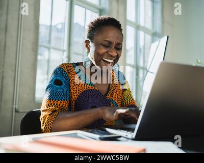 Crier femme d'affaires à l'aide d'un ordinateur portable au bureau dans le bureau Banque D'Images