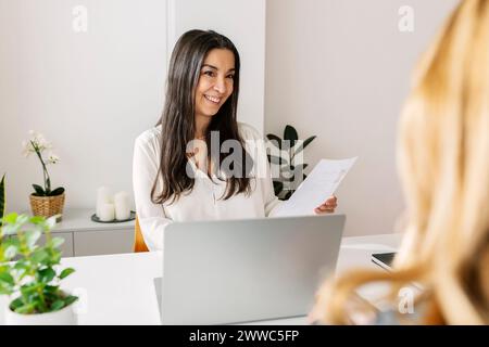 Heureux responsable RH tenant le curriculum vitae et discutant avec le candidat en poste Banque D'Images