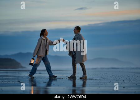 Young couple holding hands at beach Banque D'Images