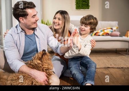 Heureuse mère avec père et fils donnant high-cinq à la maison Banque D'Images