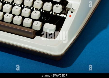 Machine à écrire rétro sur fond bleu Banque D'Images