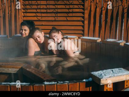 Amis assis et se détendre dans le bain à remous du spa de santé Banque D'Images