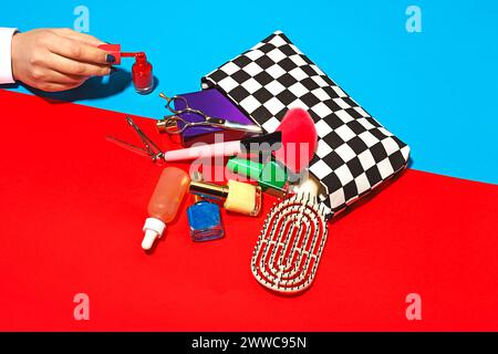 Photo studio d'une main féminine touchant des cosmétiques tombant du sac à main à carreaux Banque D'Images