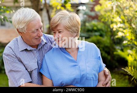Heureux homme senior embrassant la femme dans le jardin Banque D'Images