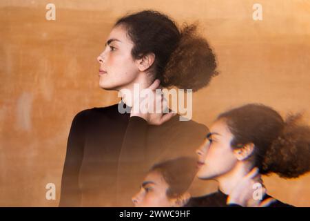 Exposition multiple d'une jeune femme avec chignon de cheveux devant le mur Banque D'Images