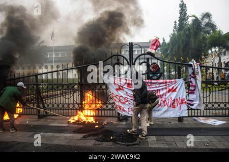 Bandung, Indonésie. 22 mars 2024. Des étudiants indonésiens brûlent des pneus et déploient des affiches devant le bureau du gouverneur de Java occidental lors d'une manifestation à Bandung. Dans cette action, ils ont exigé que le gouvernement puisse stabiliser les prix des produits de base et rejeter la politisation de l'aide sociale (photo de Dimas Rachmatsyah/Pacific Press) crédit : Pacific Press Media production Corp./Alamy Live News Banque D'Images