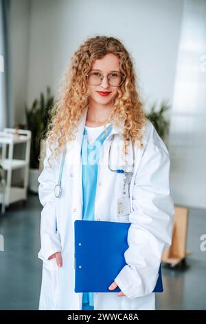 Médecin portant une blouse de laboratoire et tenant une planche à pince à la clinique Banque D'Images