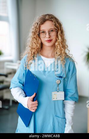 Docteur avec les cheveux bouclés portant des gommages à l'hôpital Banque D'Images