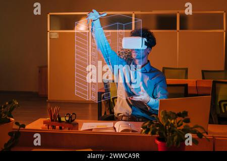 Architecte portant simulateur de réalité virtuelle et examinant l'interface de plan dans le bureau Banque D'Images