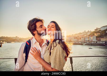 Homme heureux embrassant femme devant le fleuve Douro à Porto, Portugal Banque D'Images