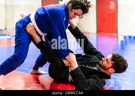 Athlètes en duel dans l'entraînement de jujitsu au dojo Banque D'Images