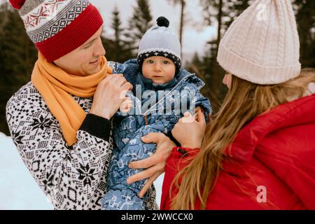 Petit garçon mignon avec des parents dans la forêt d'hiver Banque D'Images