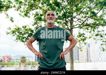 Homme senior actif debout avec les bras akimbo Banque D'Images