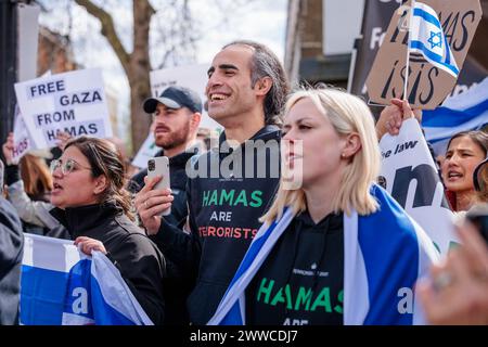 Camden, Londres, Royaume-Uni. 23 mars 2024. Lors d'une contre-manifestation officielle, un collectif de résidents britanniques concernés et de citoyens de toutes confessions, s'unissent contre la montée de la haine dans les rues de Londres. Niyak Ghorbani et Emily Schrader portent des sweats à capuche « le Hamas est terroriste », promouvant la politique gouvernementale ; « le Hamas est un groupe terroriste ». Un iranien basé à Londres, Ghorbani, a récemment été arrêté par la police métropolitaine alors qu'il était agressé pour avoir porté le même signe lors d'une marche pro-Palestine. Photo par Amanda Rose/Alamy Live News Banque D'Images