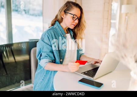 Femme effectuant le paiement en ligne par ordinateur portable à la maison Banque D'Images