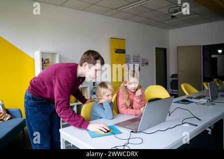 Adolescent aidant les élèves à coder en classe Banque D'Images