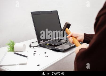 Un employé de bureau a brisé un ordinateur portable, détruit un ordinateur. Colère haine, irritation. Erreur, frein, dysfonctionnement, ne veut pas travailler. Mauvaises émotions. dep Banque D'Images