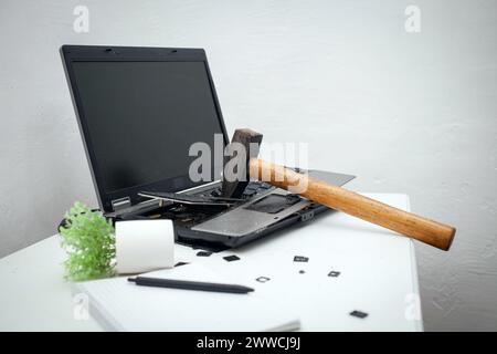 L'homme a détruit l'ordinateur portable avec un marteau. Travail nerveux, ordinateur buggy, erreurs, Internet lent, non sauvegardé dans le jeu, texte imprimé, accroché. Mauvais vieux comput Banque D'Images