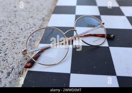 Lunettes reposant sur un échiquier en bois avec motif à carreaux Banque D'Images
