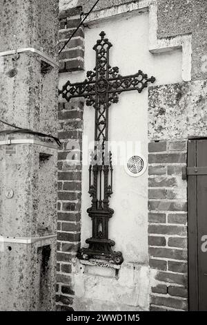 Décoratif, crucifix en fer sur un mur extérieur Banque D'Images