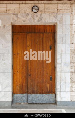 vieille porte en bois du bâtiment public soviétique dans un mur en roche coquille et marbre Banque D'Images