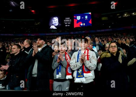 Les fans prennent part à une minute d'applaudissements en mémoire de l'ancien entraîneur anglais Terry Venables avant un match amical international au stade de Wembley, à Londres. Date de la photo : samedi 23 mars 2024. Banque D'Images